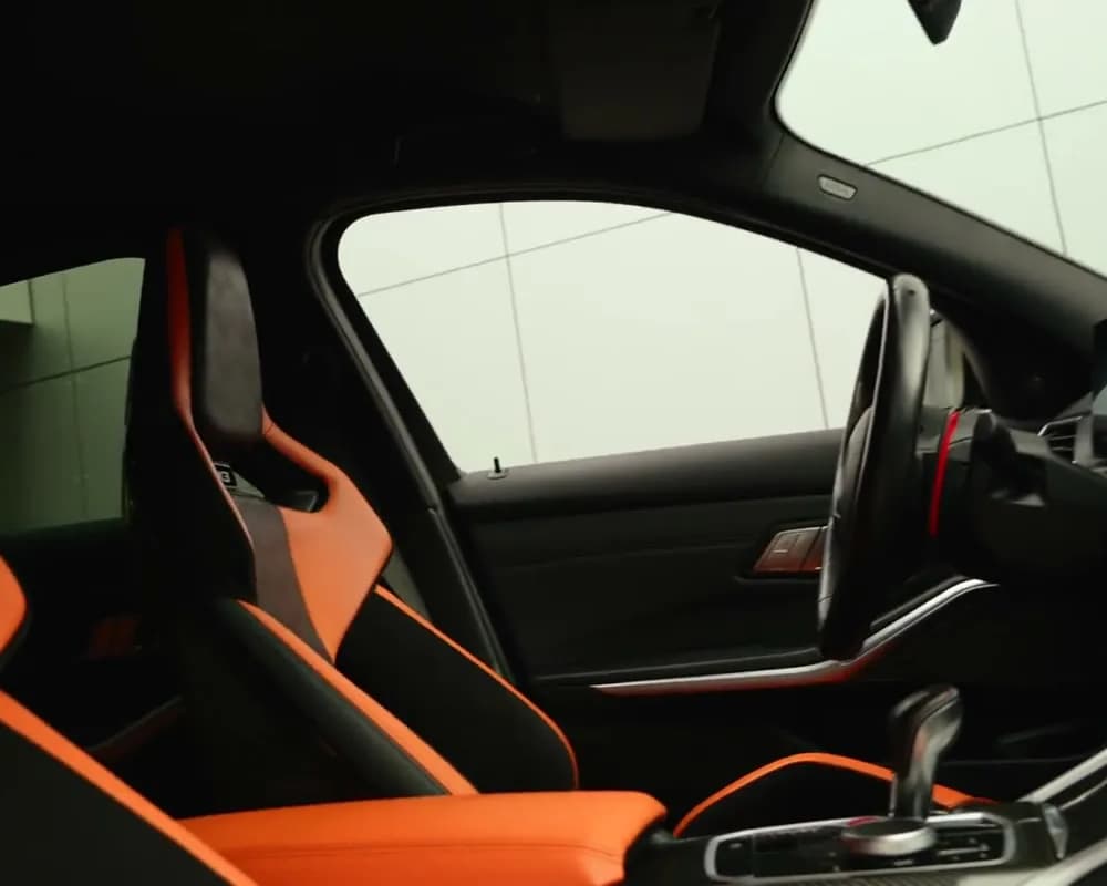 Wnętrze BMW M3 z pomarańczowymi fotelami
